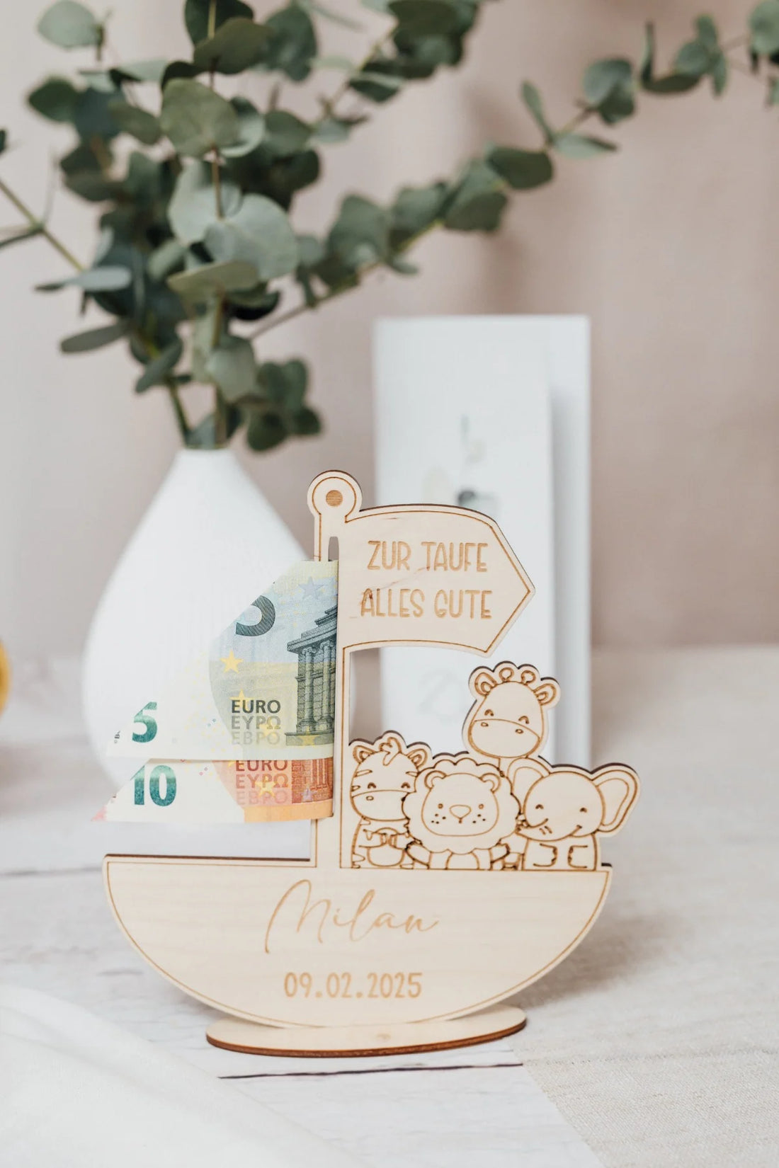 Arche Noah aus Holz mit Namen und Taufdatum, die Fahne „Zur Taufe Alles Gute“ hält einen Geldschein