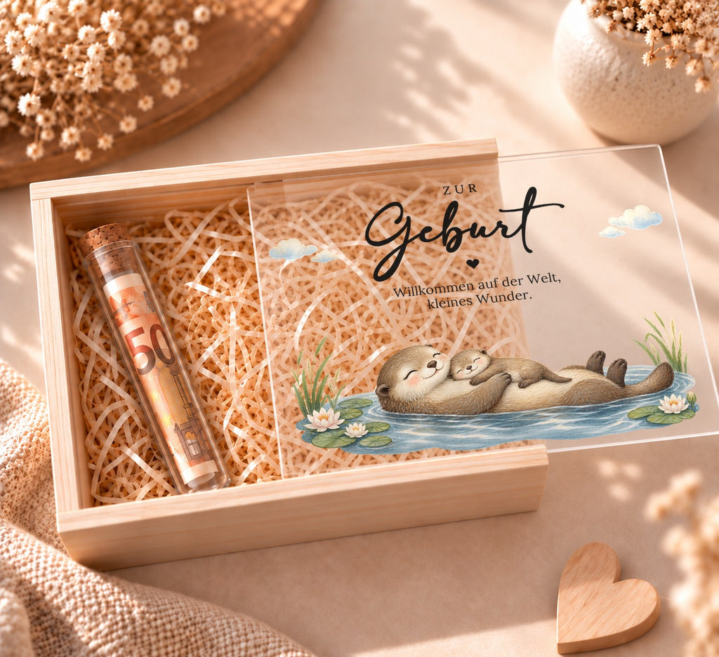 Geldgeschenk zur Geburt in Holzkiste im Otter-Design, Deckel halb offen, Reagenzglas mit Geldschein in Holzwolle