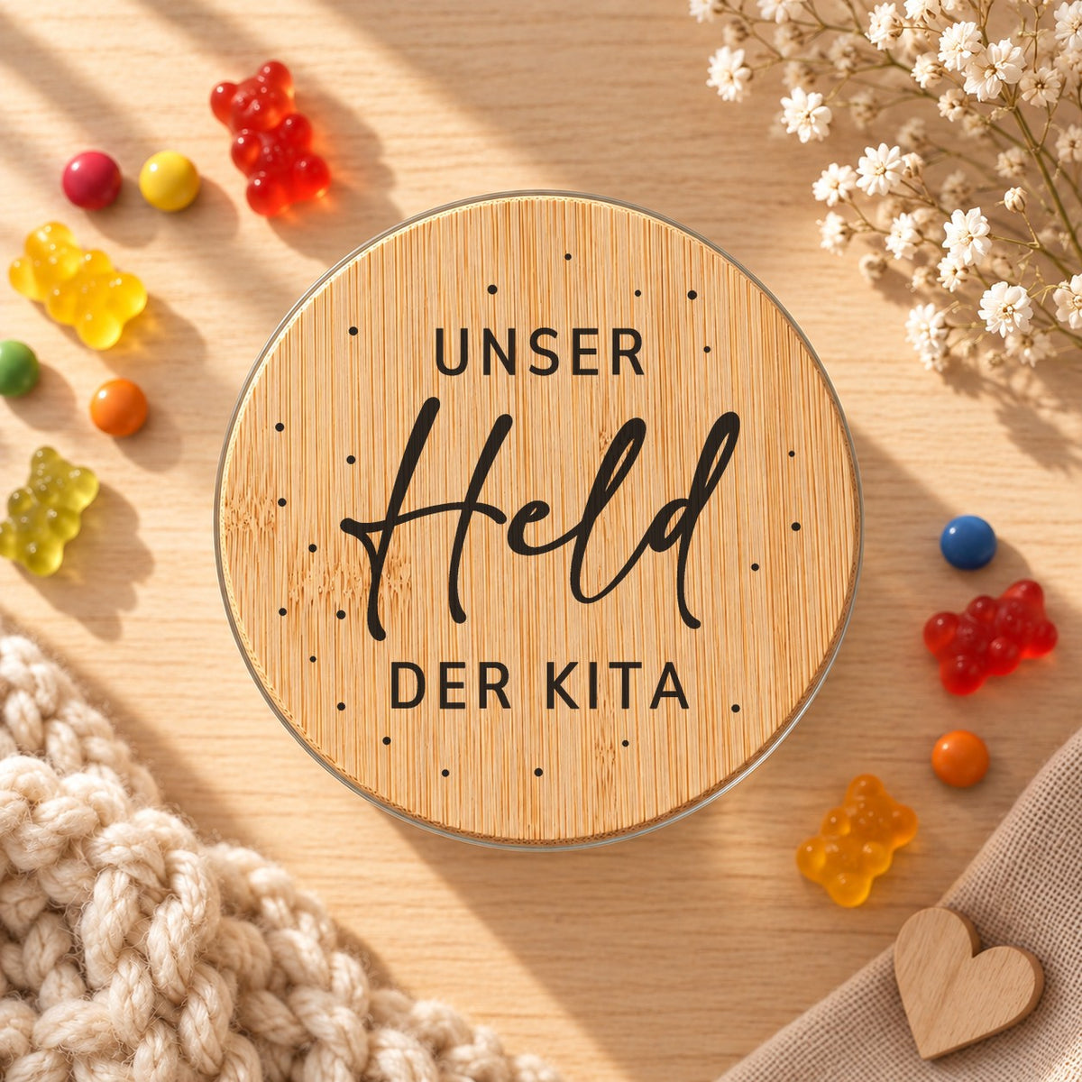 Vorratsglas „Unser Held der Kita“ als Geschenk für den Erzieher: Bambusdeckel von oben, daneben Gummibärchen