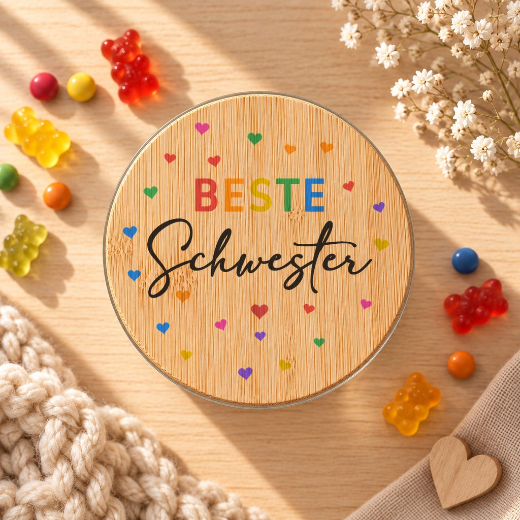 Vorratsglas „Beste Schwester“ als Geschenk für die große Schwester zur Geburt: Bambusdeckel von oben, daneben Gummibärchen
