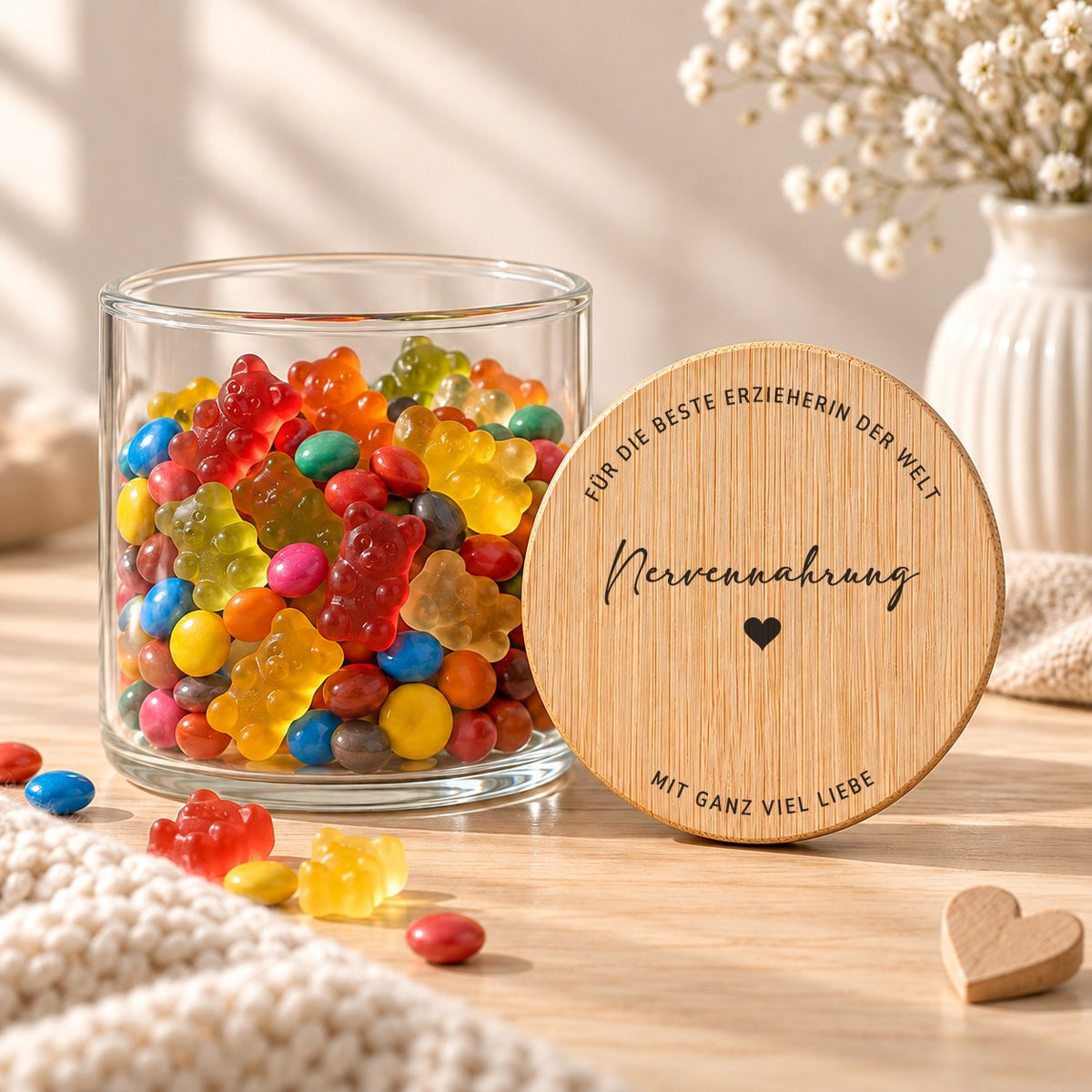 Offenes Vorratsglas mit Gummibärchen, daneben lehnt der Deckel „Nervennahrung – für die beste Erzieherin der Welt – mit ganz viel Liebe“