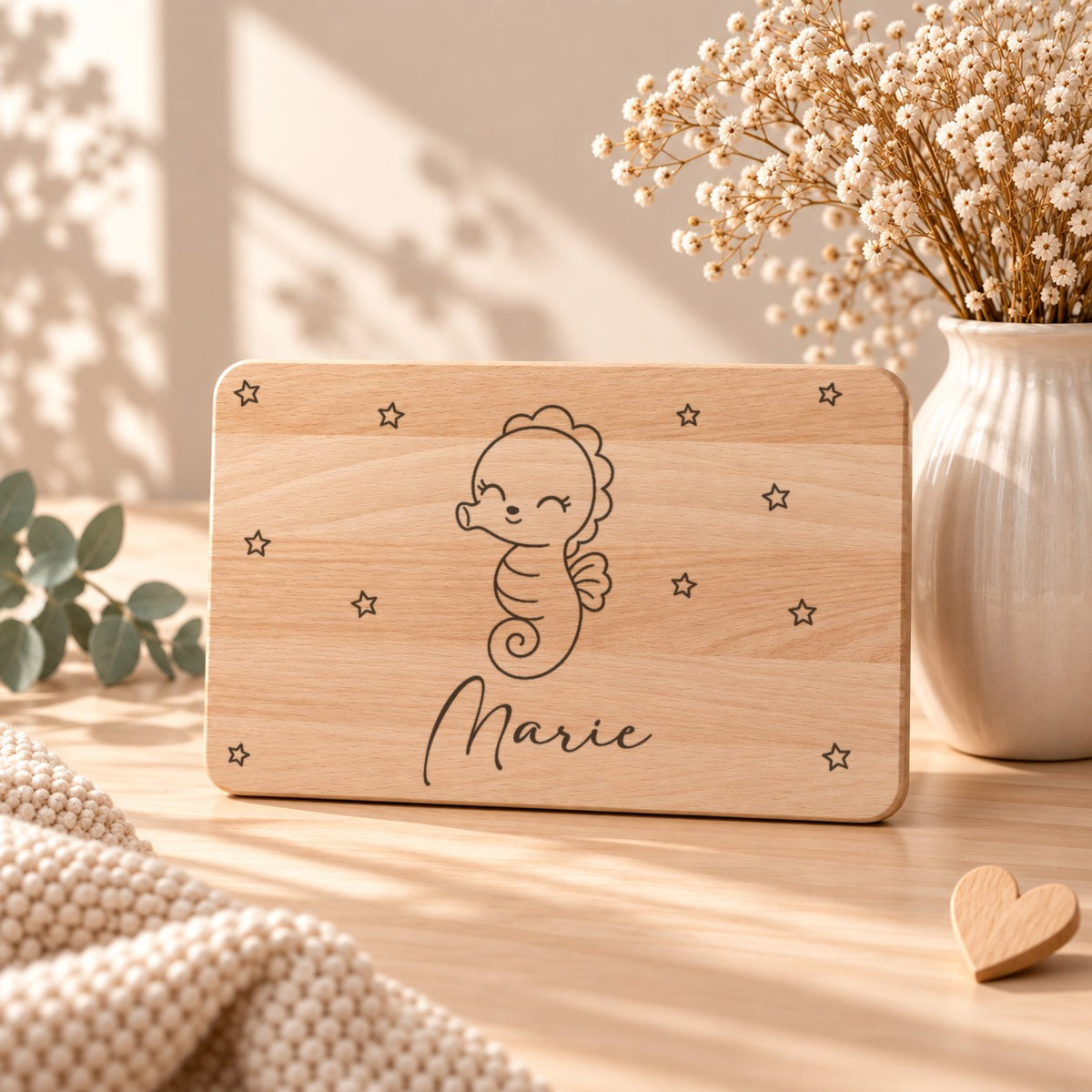 Frühstücksbrettchen aus Holz mit einem Seepferdchen, aufgestellt neben Schleierkraut