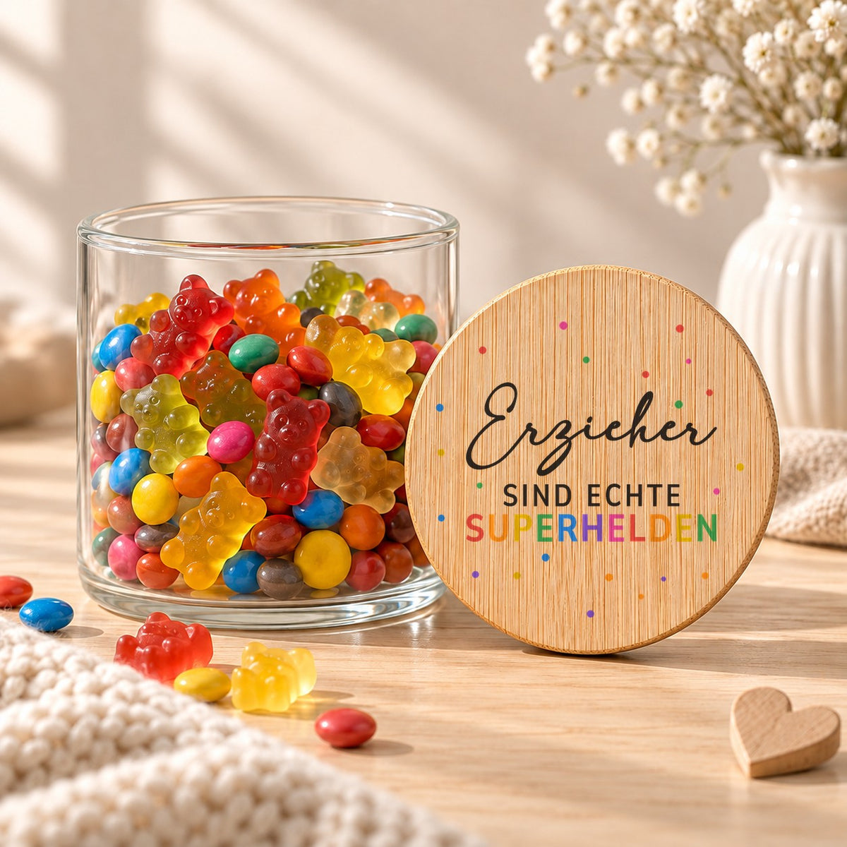 Offenes Vorratsglas mit Gummibärchen, daneben lehnt der Deckel „Erzieher sind echte Superhelden“