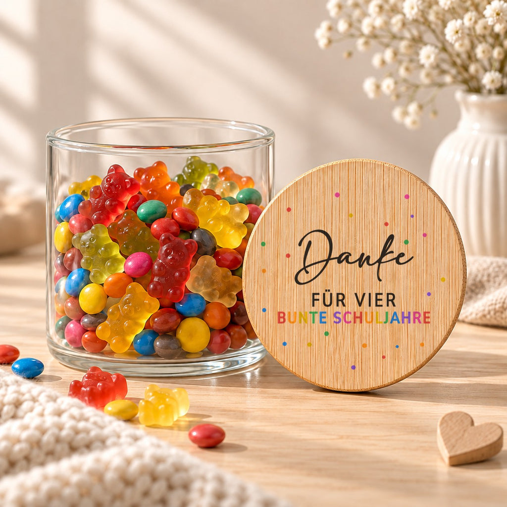 Offenes Vorratsglas mit Gummibärchen, daneben lehnt der Deckel „Danke für vier bunte Schuljahre“