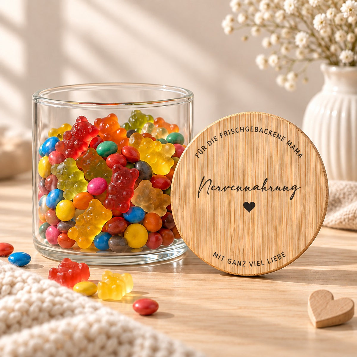 Offenes Vorratsglas mit Gummibärchen, daneben lehnt der Deckel „Nervennahrung – für die frischgebackene Mama – mit ganz viel Liebe“
