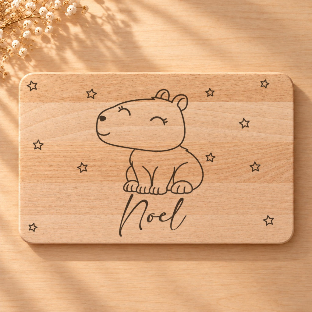 Nahaufnahme der Lasergravur: Capybara und der Name Noel in Schreibschrift auf hellem Holz