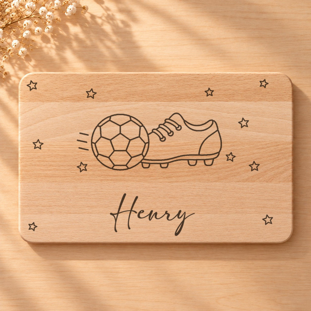 Nahaufnahme der Lasergravur: Fußball und der Name Henry in Schreibschrift auf hellem Holz