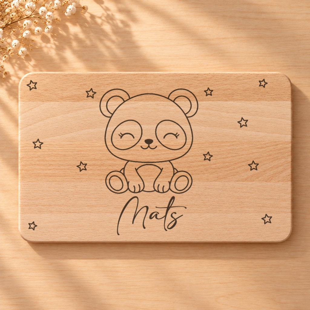 Nahaufnahme der Lasergravur: Panda und der Name Mats in Schreibschrift auf hellem Holz