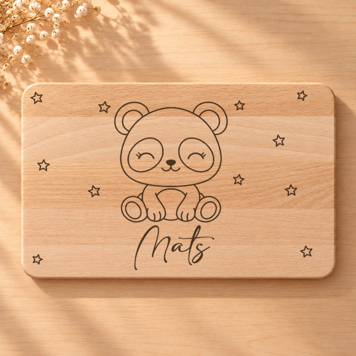 Nahaufnahme der Lasergravur: Panda und der Name Mats in Schreibschrift auf hellem Holz