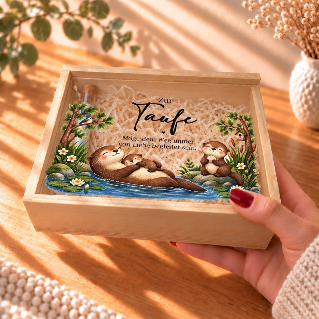 Holzkiste zur Taufe mit Otter-Motiv in der Hand gehalten