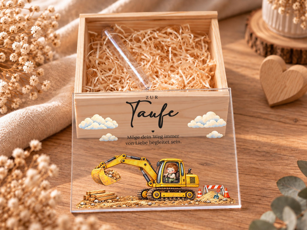 Offene Taufkiste mit Holzwolle und Reagenzglas, Acryldeckel mit Bagger davor