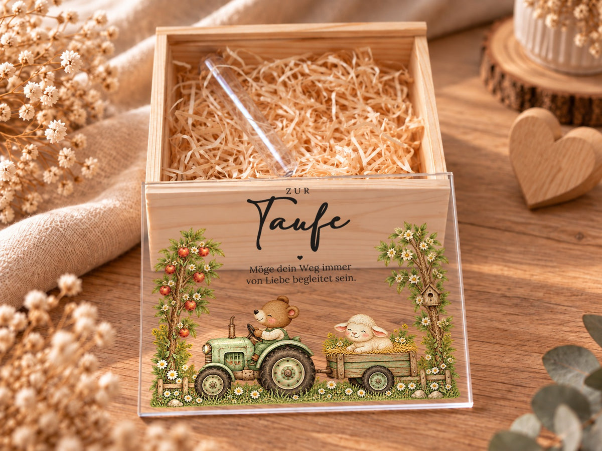 Offene Taufkiste mit Holzwolle und Reagenzglas, Acryldeckel mit Traktor davor