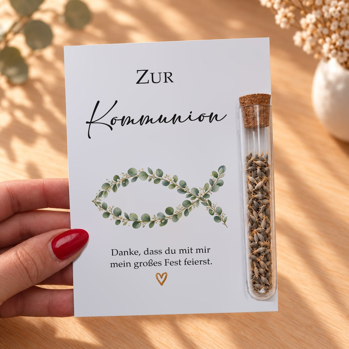 Gastgeschenk zur Kommunion mit Eukalyptus-Fisch in der Hand