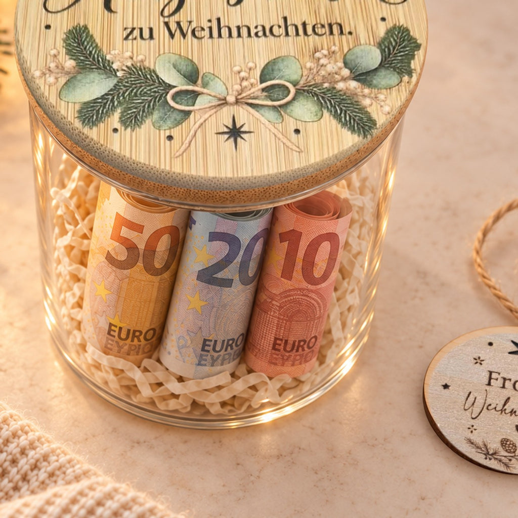 Geld im Glas verschenken: gerollte 50-, 20- und 10-Euro-Scheine in Holzwolle unter dem Deckel „Herzenswunsch“