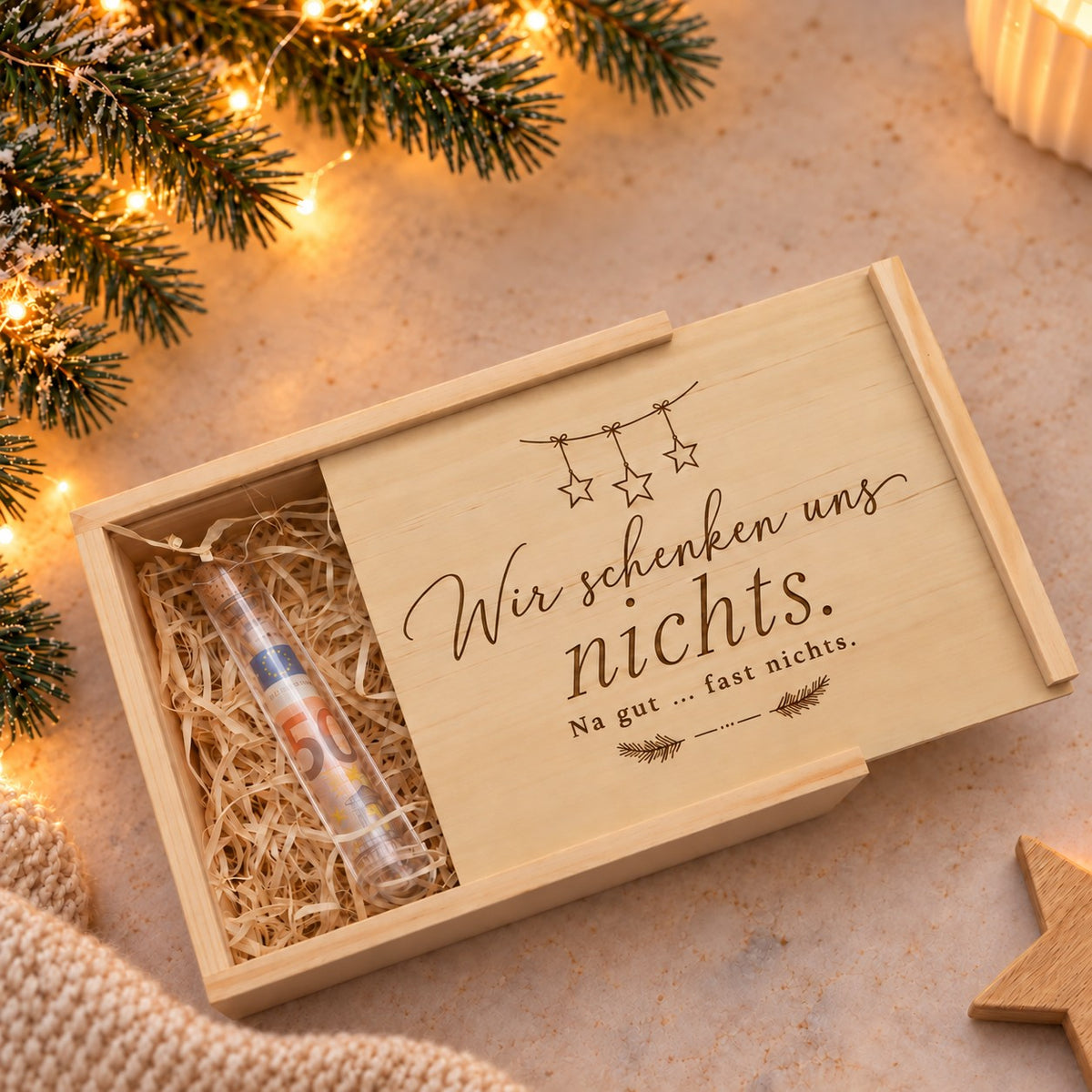 Design Sterne: Holzkiste mit Sternengirlande und Gravur „Wir schenken uns nichts“, Geldschein im Reagenzglas