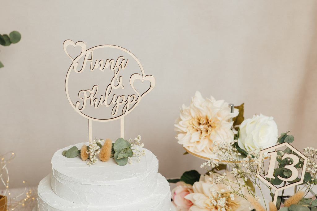 Runder Caketopper aus Holz auf einer Hochzeitstorte mit Trockenblumen