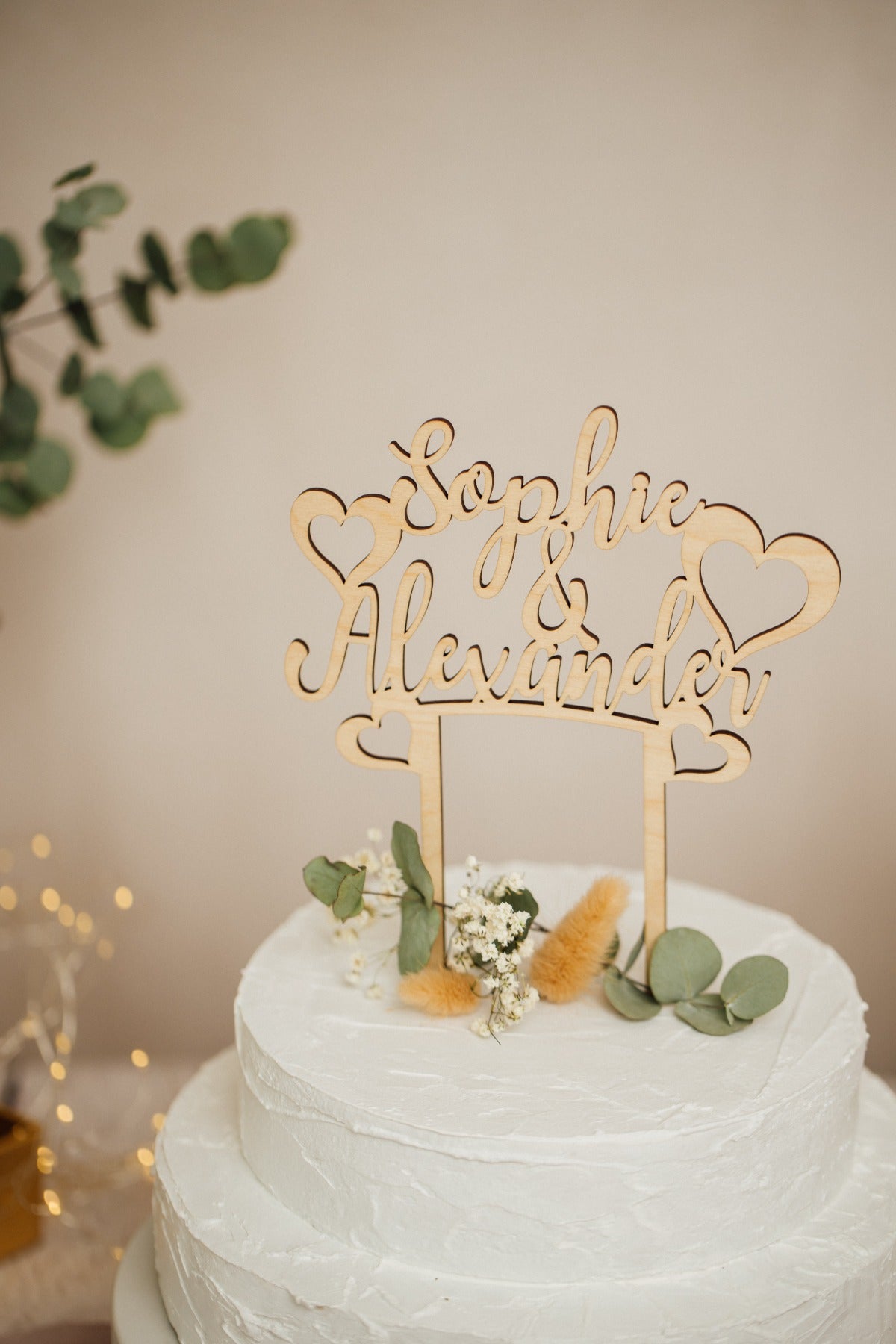 Caketopper zur Hochzeit mit Namen und Herzen in der Nahaufnahme auf der Torte