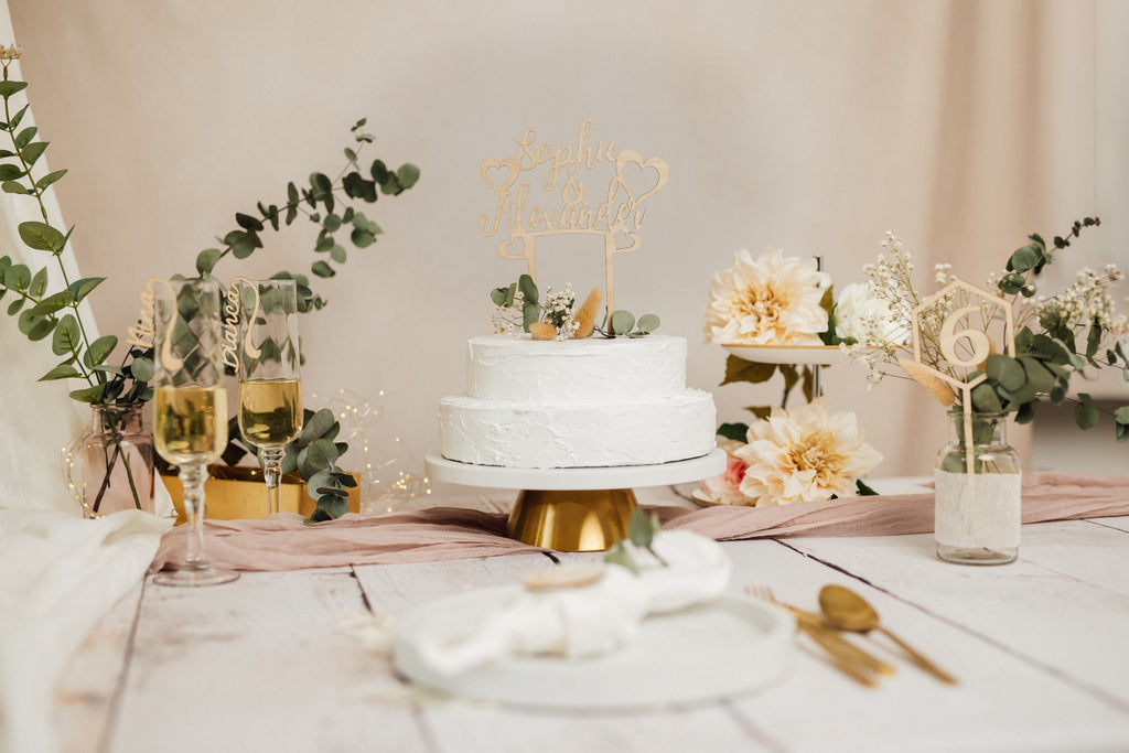 Hochzeitstorte mit personalisiertem Caketopper auf einem gedeckten Tisch