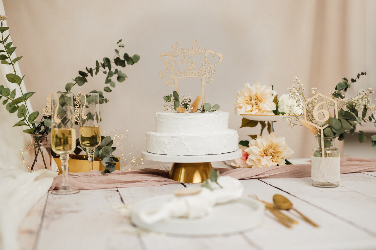 Hochzeitstorte mit personalisiertem Caketopper auf einem gedeckten Tisch