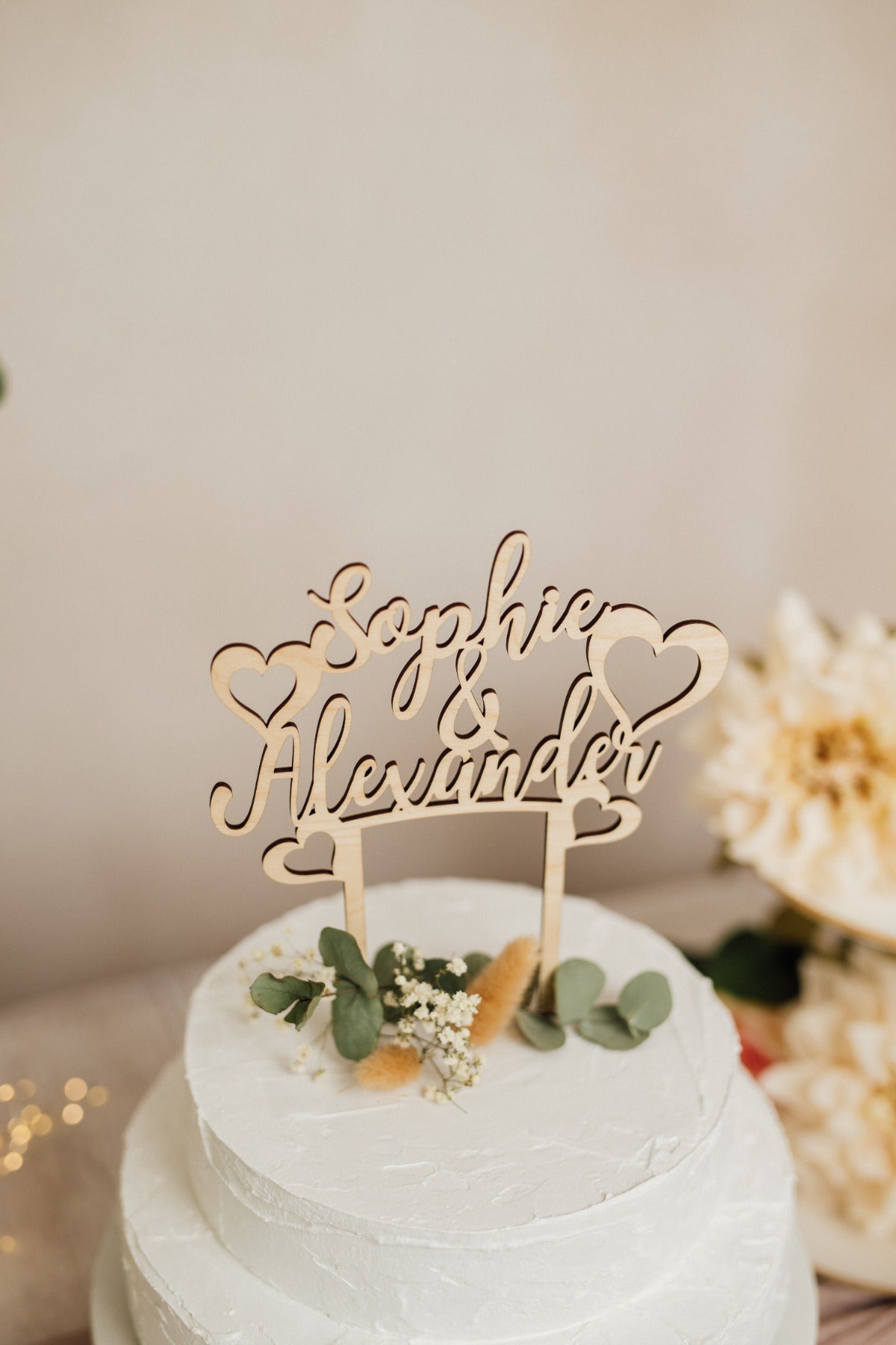 Personalisierter Caketopper zur Hochzeit aus Holz mit den Namen Sophie & Alexander und Herzen