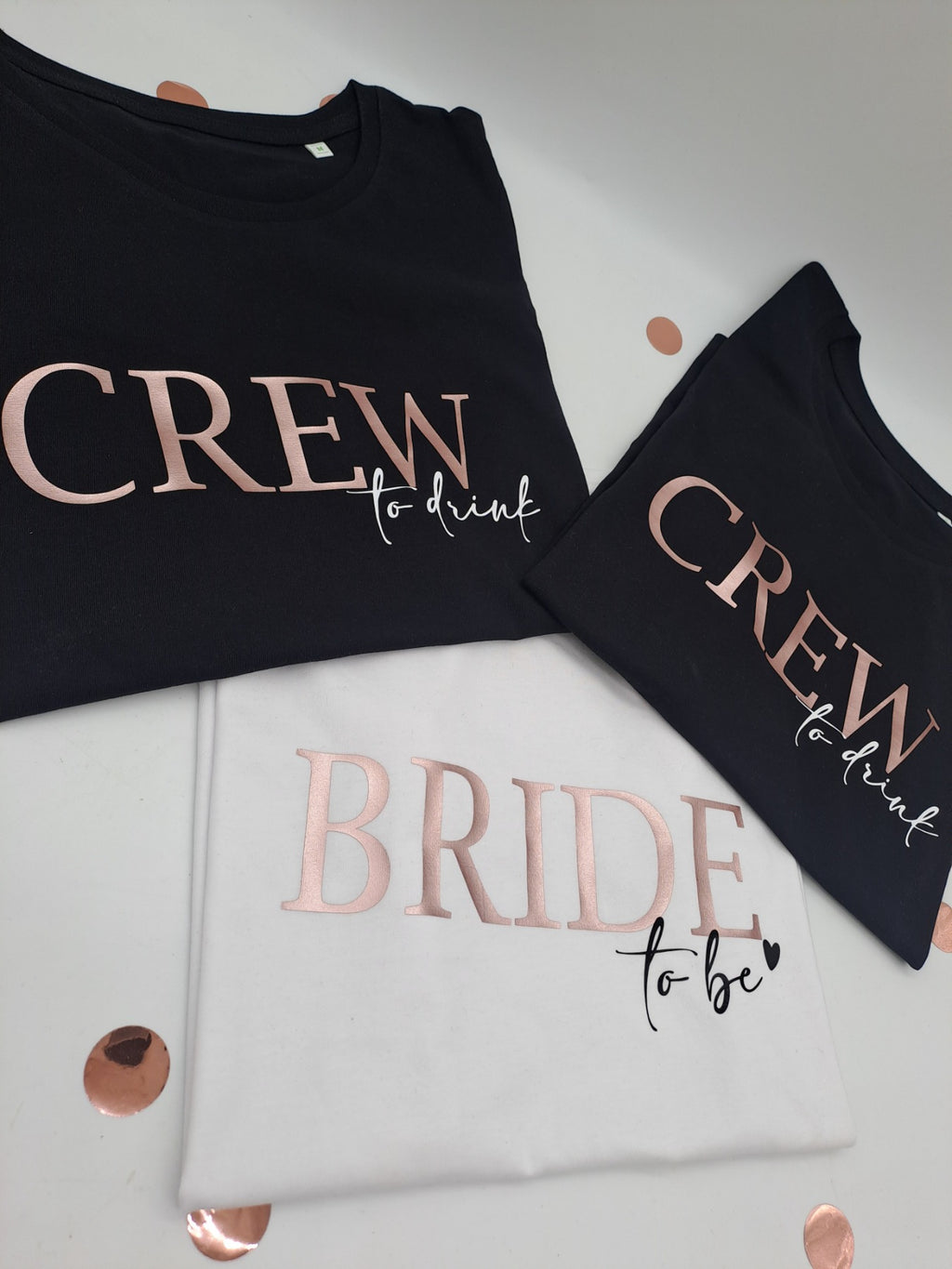 JGA-Shirts „Crew to drink“ in Schwarz und „Bride to be“ in Weiß mit Aufdruck in Roségold