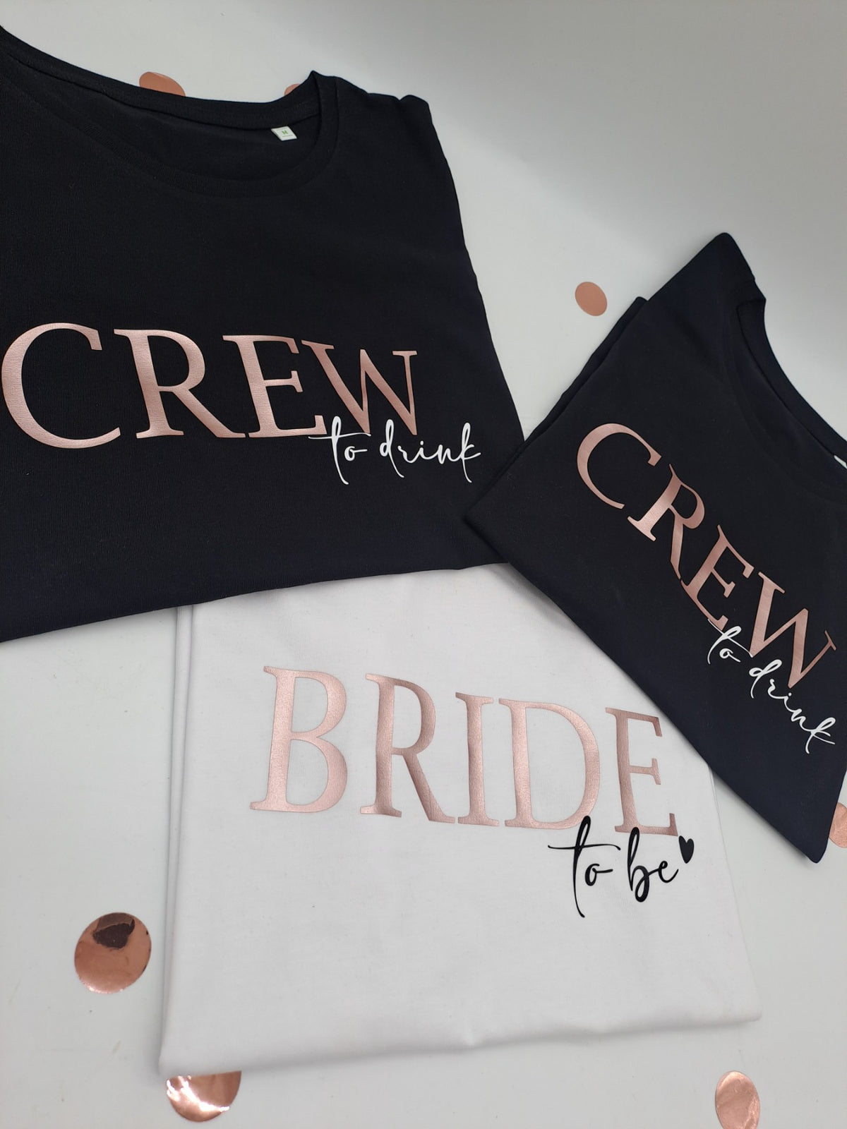 JGA-Shirts „Crew to drink“ in Schwarz und „Bride to be“ in Weiß mit Aufdruck in Roségold